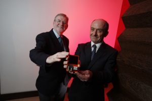 Dr. Kieran Drain, CEO of Tyndall National Institute & Mike Hayes, Senior Programme Manager, Tyndall National Institute at Tyndall Technology Day with an IoT sensor (an indoor solar powered temperature, light and humidity wireless sensor)